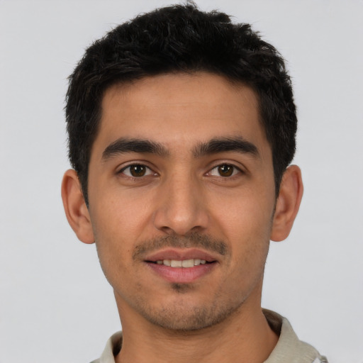 Joyful latino young-adult male with short  black hair and brown eyes