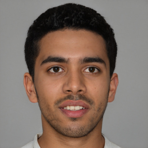 Joyful latino young-adult male with short  brown hair and brown eyes