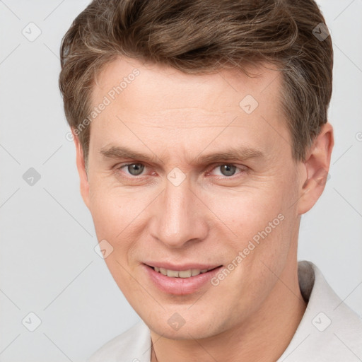 Joyful white adult male with short  brown hair and grey eyes