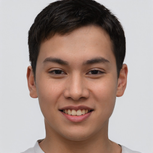 Joyful asian young-adult male with short  brown hair and brown eyes
