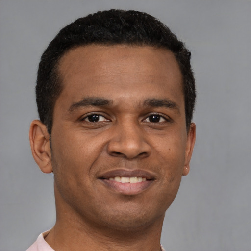 Joyful black young-adult male with short  brown hair and brown eyes