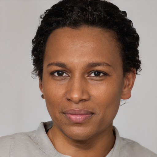 Joyful black young-adult female with short  black hair and brown eyes