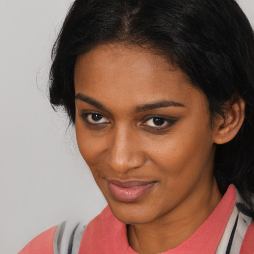 Joyful black young-adult female with medium  brown hair and brown eyes