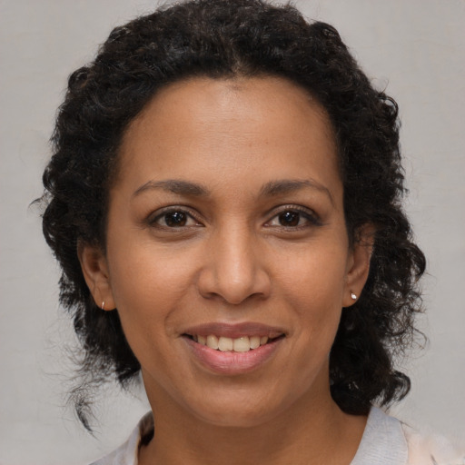 Joyful black adult female with medium  brown hair and brown eyes