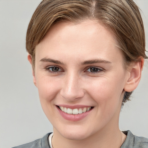 Joyful white young-adult female with short  brown hair and grey eyes