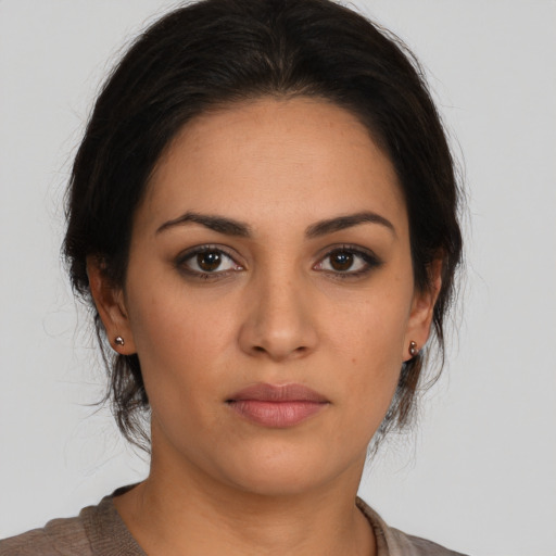 Joyful latino young-adult female with medium  brown hair and brown eyes