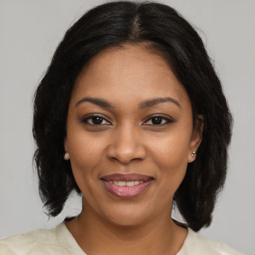 Joyful black young-adult female with medium  brown hair and brown eyes