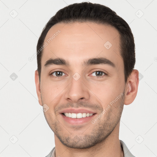 Joyful white young-adult male with short  brown hair and brown eyes