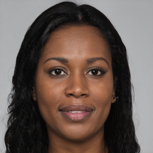 Joyful black young-adult female with long  brown hair and brown eyes