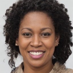 Joyful black adult female with long  brown hair and brown eyes