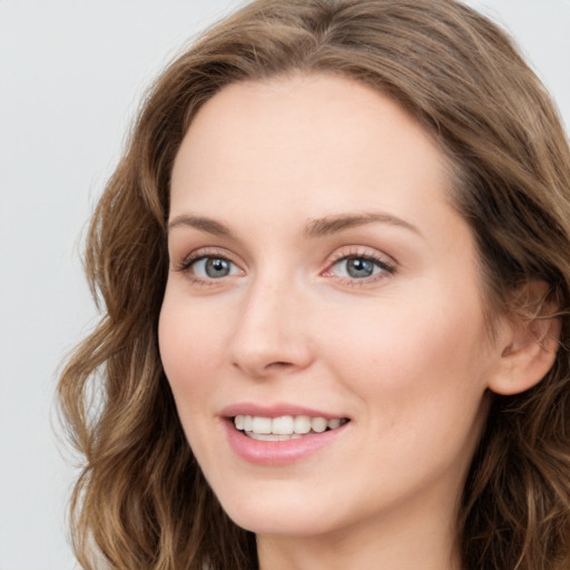 Joyful white young-adult female with long  brown hair and blue eyes