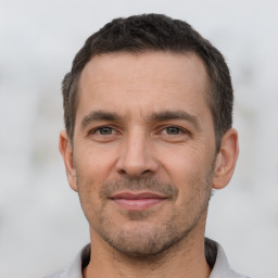 Joyful white adult male with short  brown hair and brown eyes