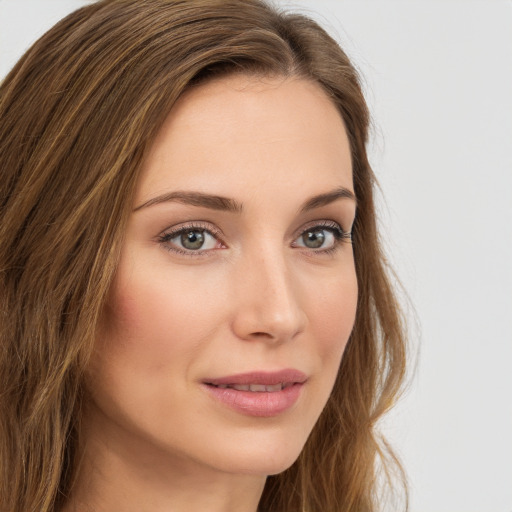 Joyful white young-adult female with long  brown hair and green eyes