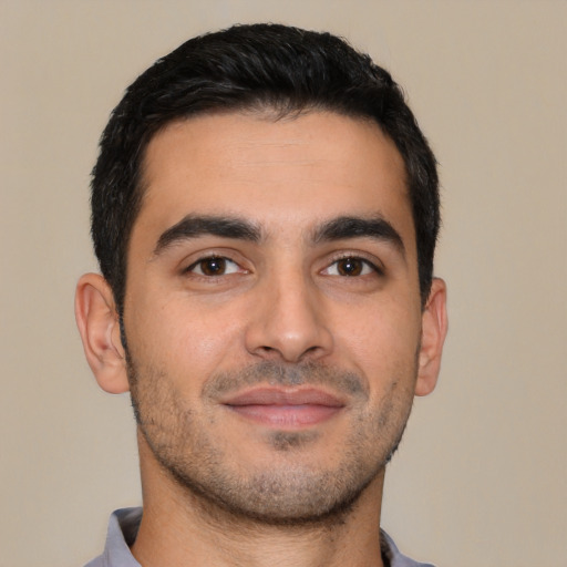 Joyful latino young-adult male with short  brown hair and brown eyes