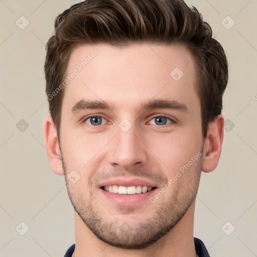 Joyful white young-adult male with short  brown hair and grey eyes