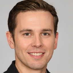 Joyful white adult male with short  brown hair and grey eyes