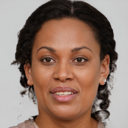 Joyful black adult female with medium  brown hair and brown eyes