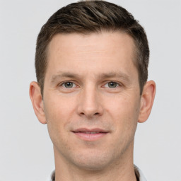 Joyful white young-adult male with short  brown hair and grey eyes