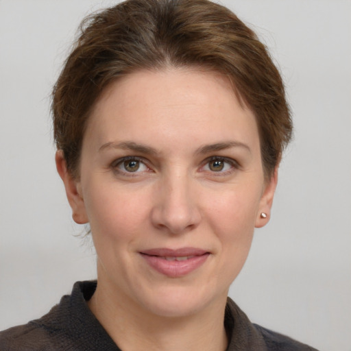 Joyful white young-adult female with short  brown hair and grey eyes