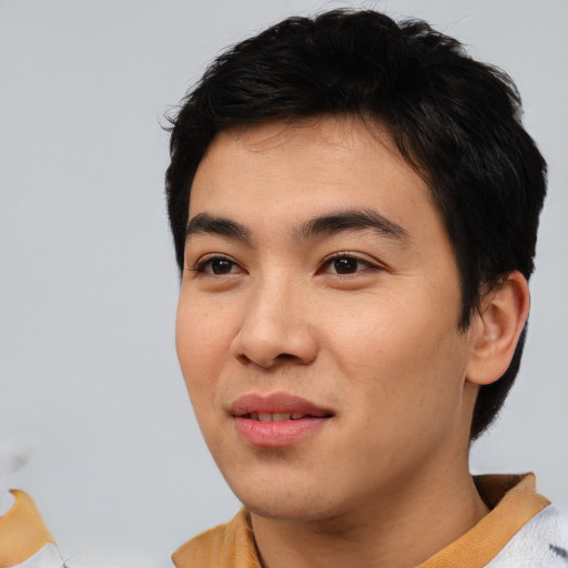 Joyful asian young-adult male with short  black hair and brown eyes