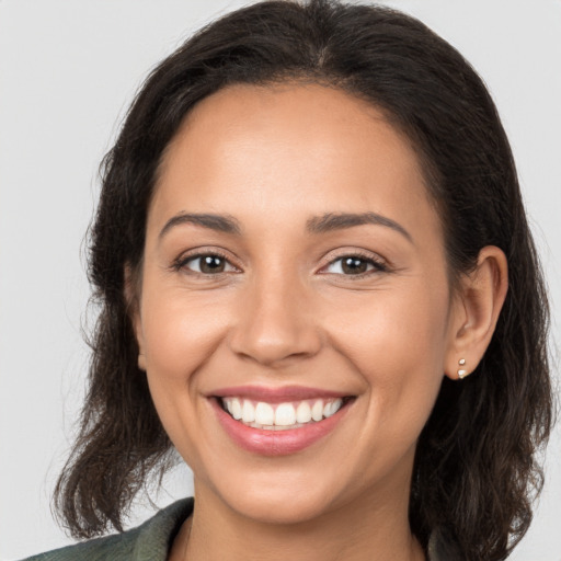 Joyful white young-adult female with long  brown hair and brown eyes