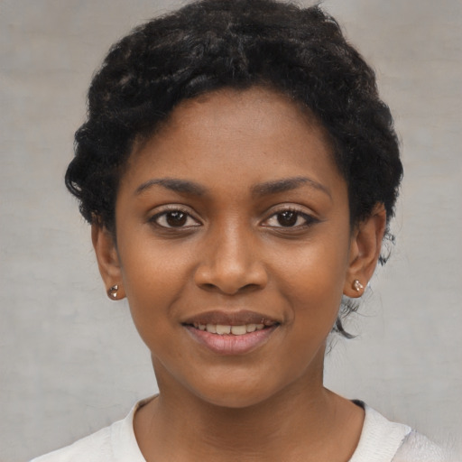 Joyful black young-adult female with short  black hair and brown eyes