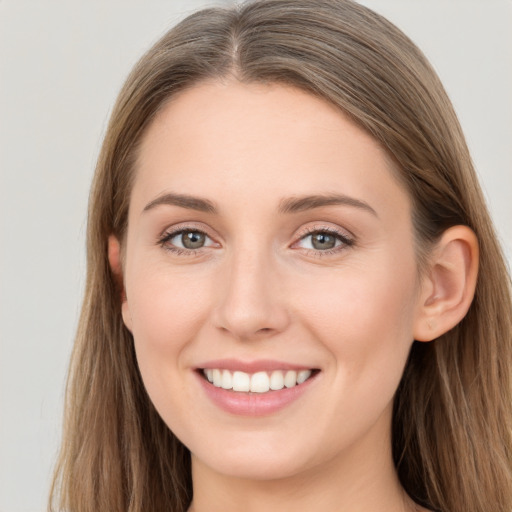 Joyful white young-adult female with long  brown hair and grey eyes