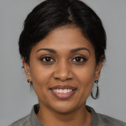 Joyful black young-adult female with medium  brown hair and brown eyes