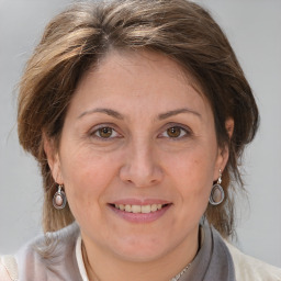 Joyful white adult female with medium  brown hair and brown eyes