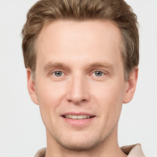 Joyful white young-adult male with short  brown hair and grey eyes