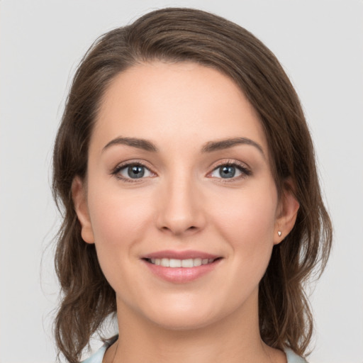 Joyful white young-adult female with medium  brown hair and grey eyes