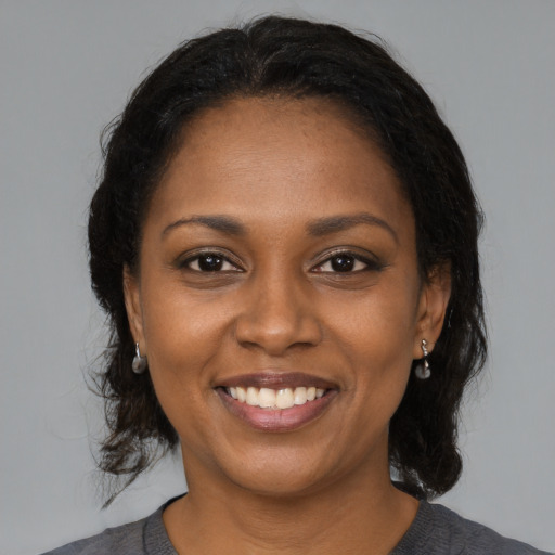 Joyful black young-adult female with medium  black hair and brown eyes