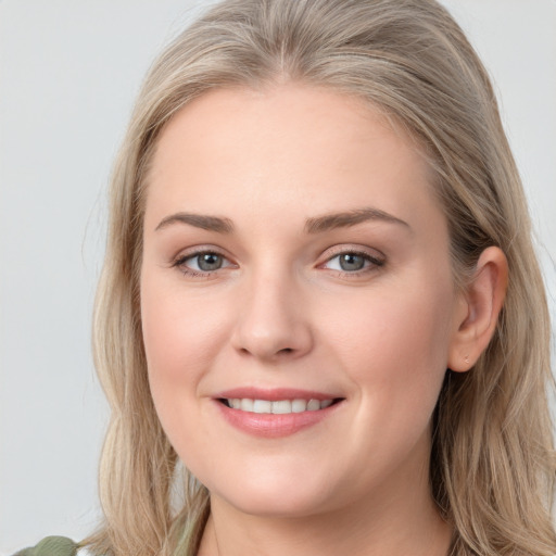 Joyful white young-adult female with long  brown hair and blue eyes