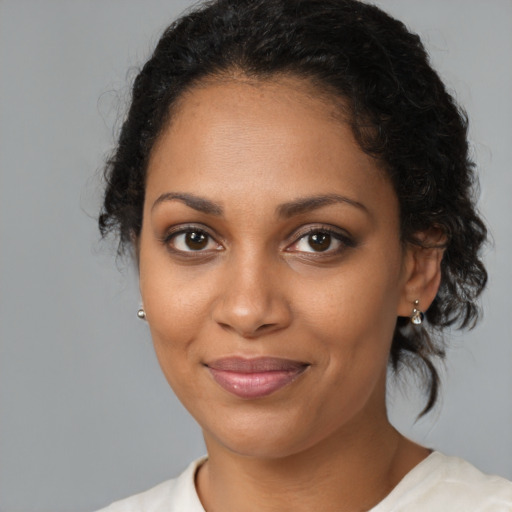 Joyful black young-adult female with medium  brown hair and brown eyes