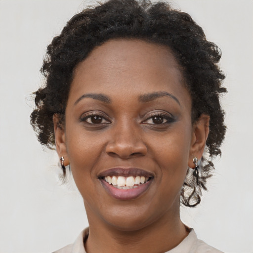 Joyful black young-adult female with short  brown hair and brown eyes