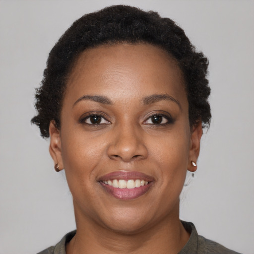 Joyful black young-adult female with short  brown hair and brown eyes