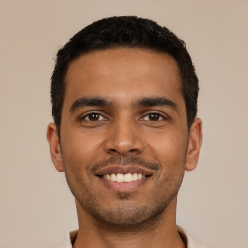 Joyful latino young-adult male with short  black hair and brown eyes