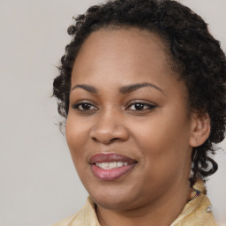 Joyful black young-adult female with long  brown hair and brown eyes