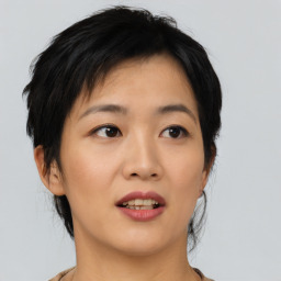 Joyful asian young-adult female with medium  black hair and brown eyes