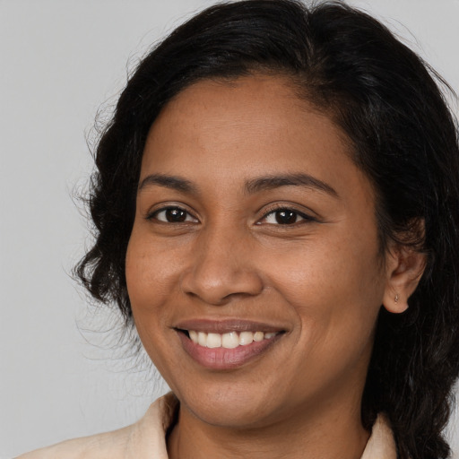 Joyful black young-adult female with long  brown hair and brown eyes