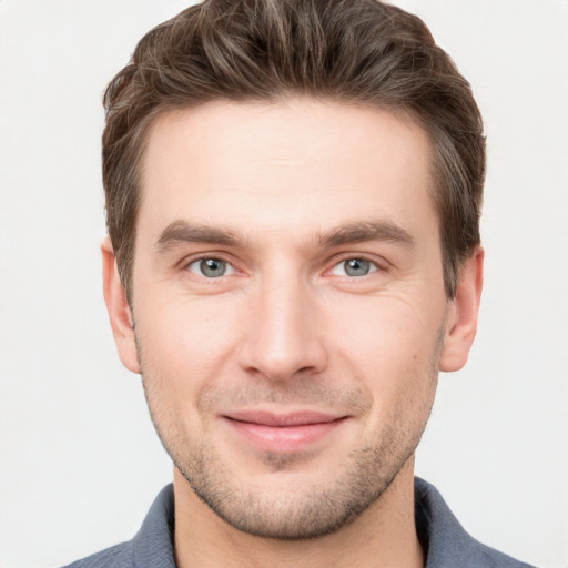 Joyful white young-adult male with short  brown hair and grey eyes