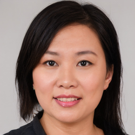 Joyful asian young-adult female with medium  brown hair and brown eyes