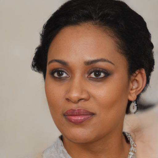 Joyful black young-adult female with short  brown hair and brown eyes