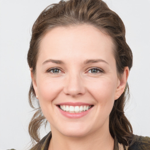 Joyful white young-adult female with medium  brown hair and grey eyes