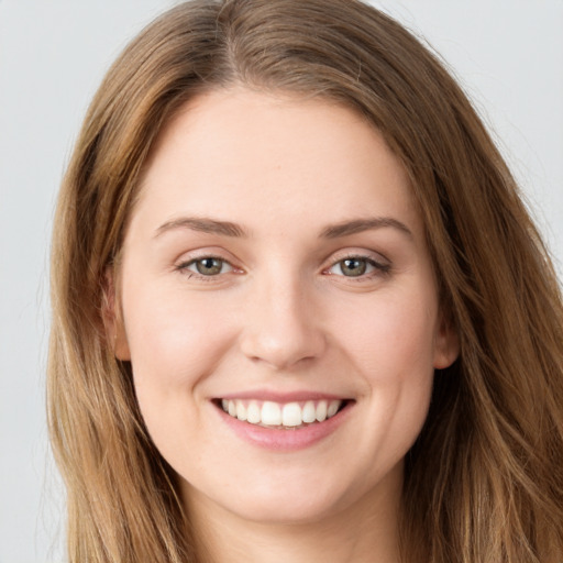 Joyful white young-adult female with long  brown hair and green eyes