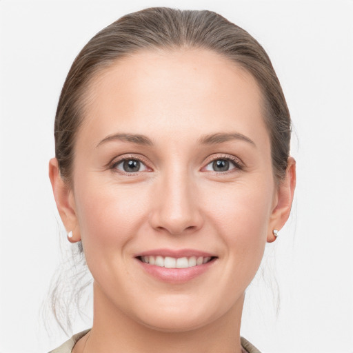 Joyful white young-adult female with medium  brown hair and grey eyes