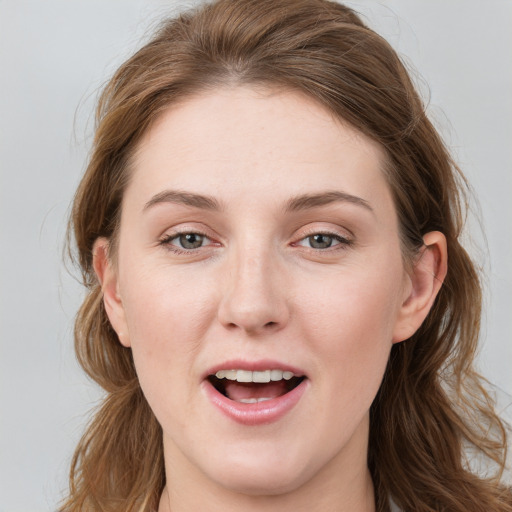 Joyful white young-adult female with long  brown hair and blue eyes