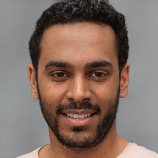 Joyful white young-adult male with short  black hair and brown eyes