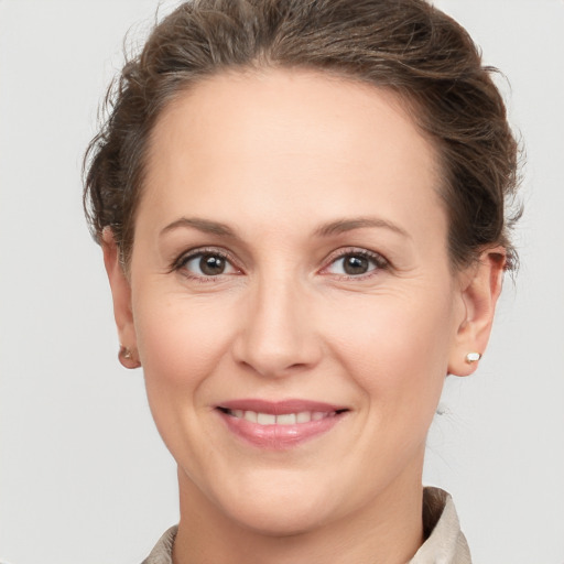 Joyful white adult female with medium  brown hair and brown eyes