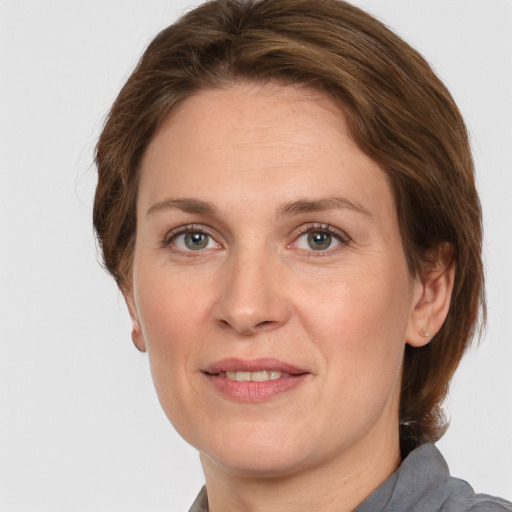 Joyful white adult female with medium  brown hair and grey eyes